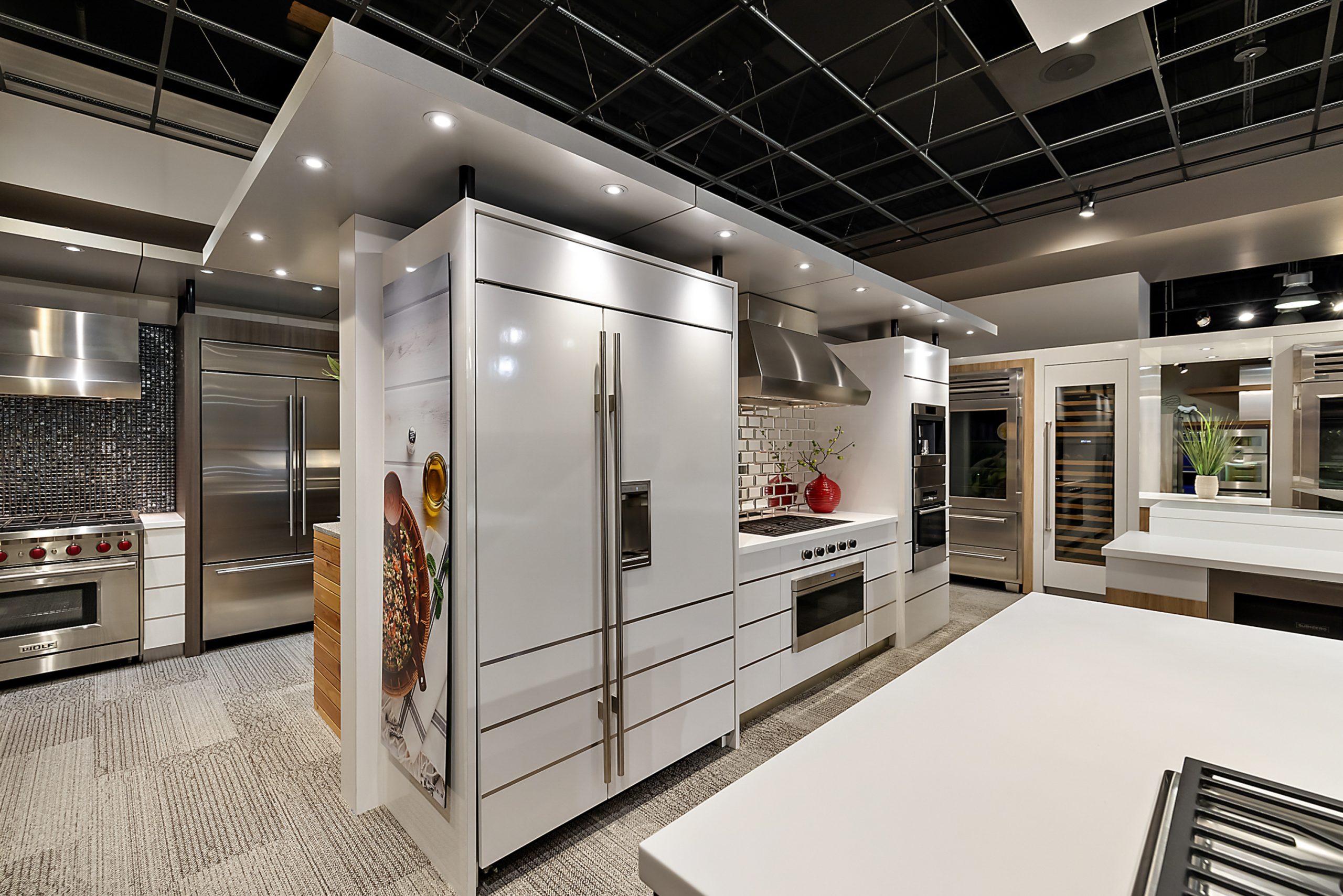 Luxury island and fridge setup featured in appliance showroom with sleek modern cabinetry